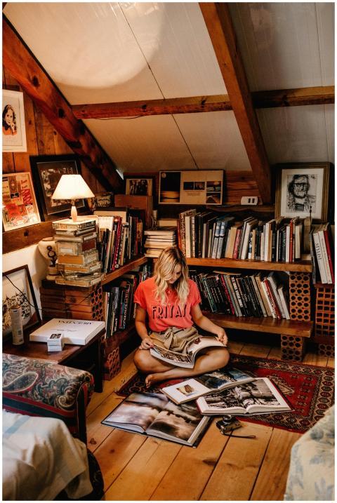 Woman reading in a cozy attic library surrounded b