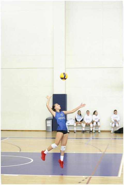 Female volleyball player serving the ball with foc