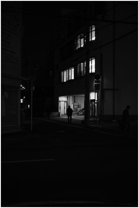 A silhouette of a person walking at night in an ur