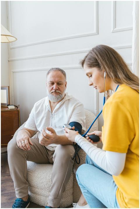 A healthcare professional checks an elderly man's