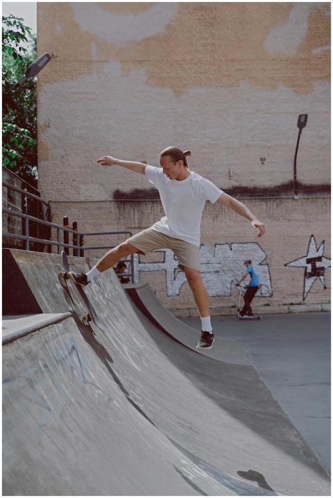 A skateboarder performs a trick at an urban skate