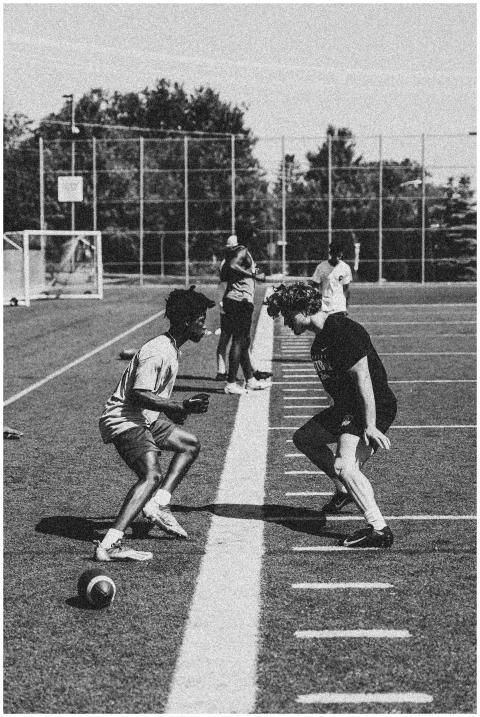 Football players practicing drills on an outdoor f