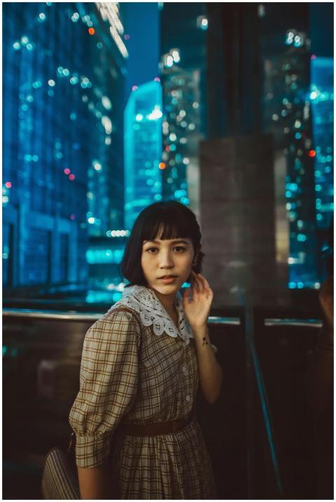 A young woman in fashionable attire with a citysca