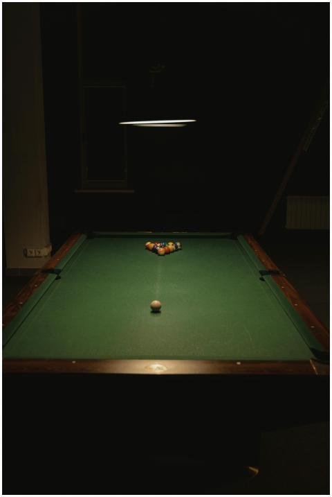 A billiard table with arranged balls under a focus