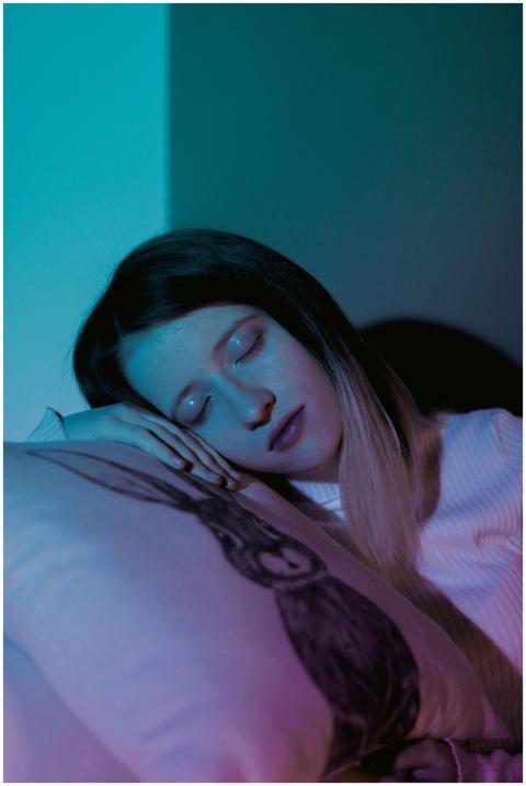 A woman peacefully sleeping on a pillow with a ser