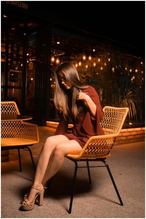 Asian woman in maroon dress sitting at a cafe with
