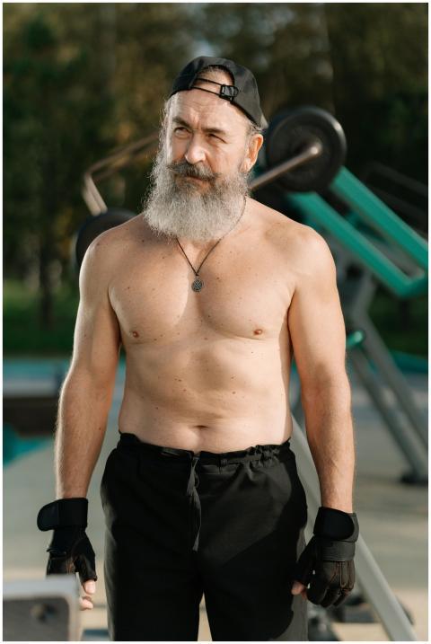 Shirtless senior man with a beard working out in a