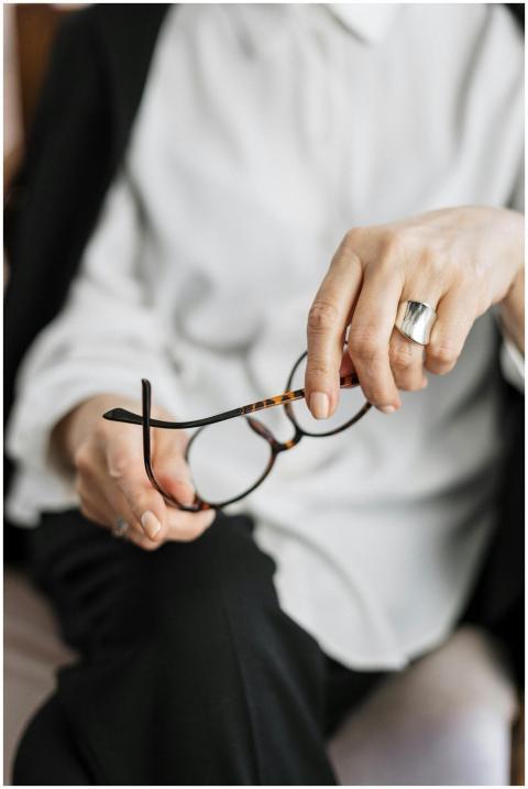 Close-up of a woman holding glasses, symbolizing t