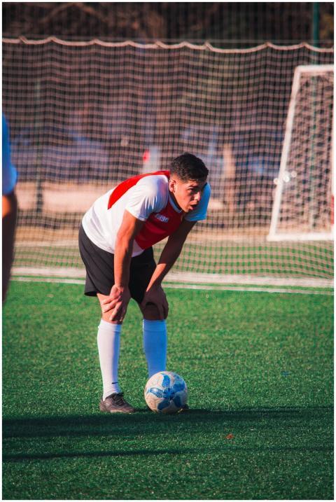 A tired soccer player resting on the field, showin