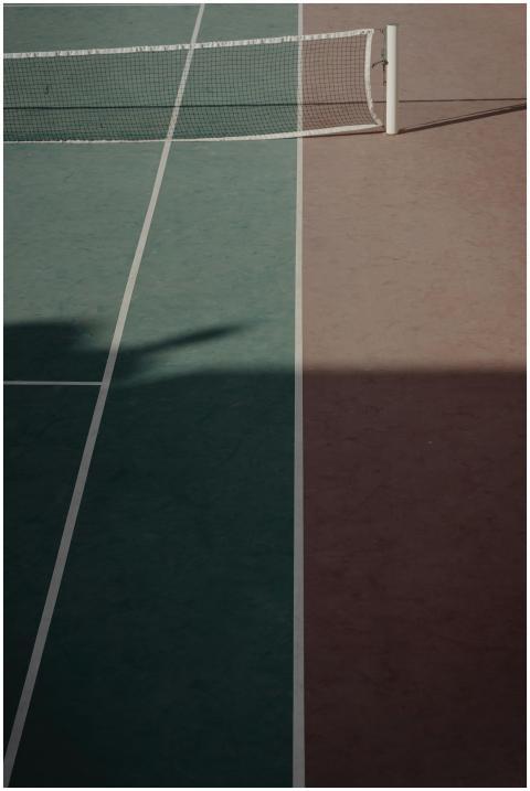 A minimalist view of a tennis court showing a net