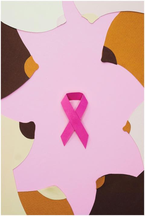 Pink ribbon symbol on an abstract multi-colored ba