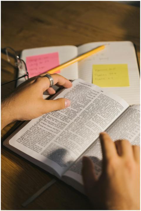 Close-up of hands holding and reading a Bible with