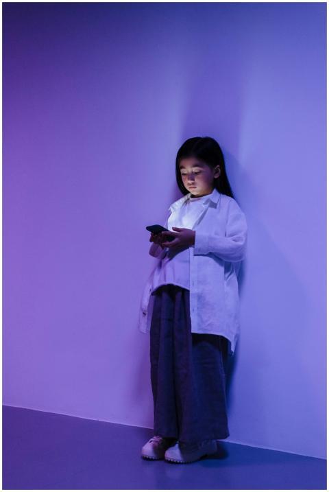 A young girl is engrossed in using a smartphone wh