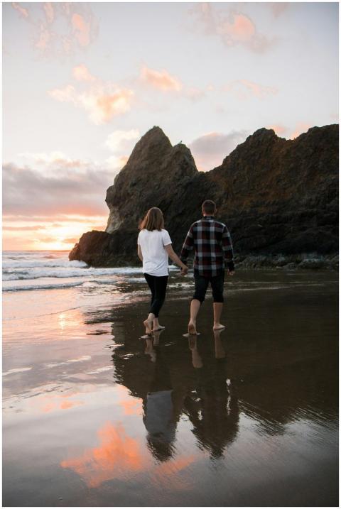 Couple walking hand in hand on Cannon Beach, Orego