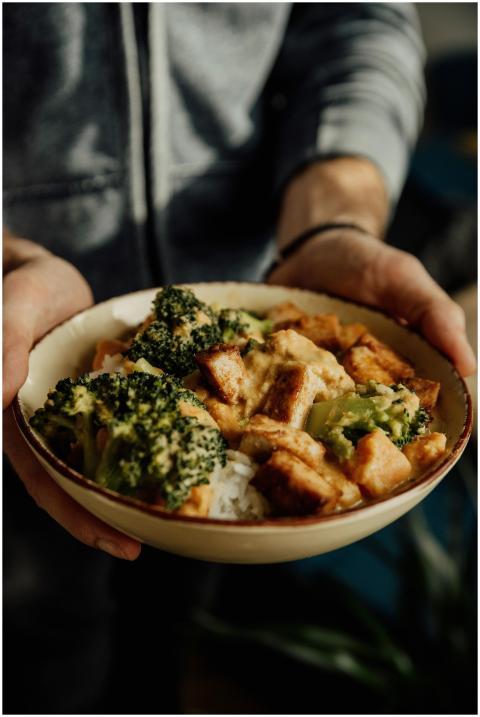 Close-up of a person holding a bowl of broccoli, t