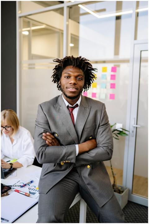 Businessman with dreadlocks in gray suit smiling c