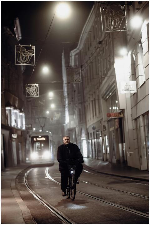 Moody urban night scene with a cyclist in front of