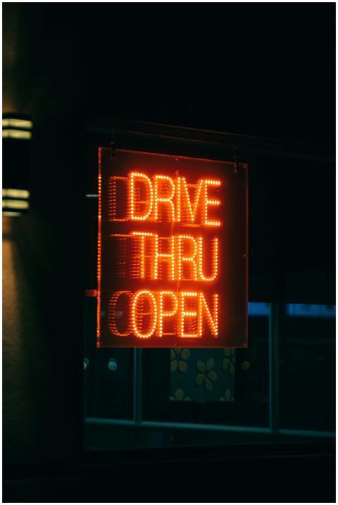Glowing neon drive-thru sign illuminated against a