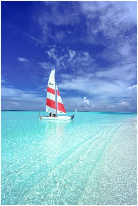 Idyllic scene of a sailboat on pristine turquoise