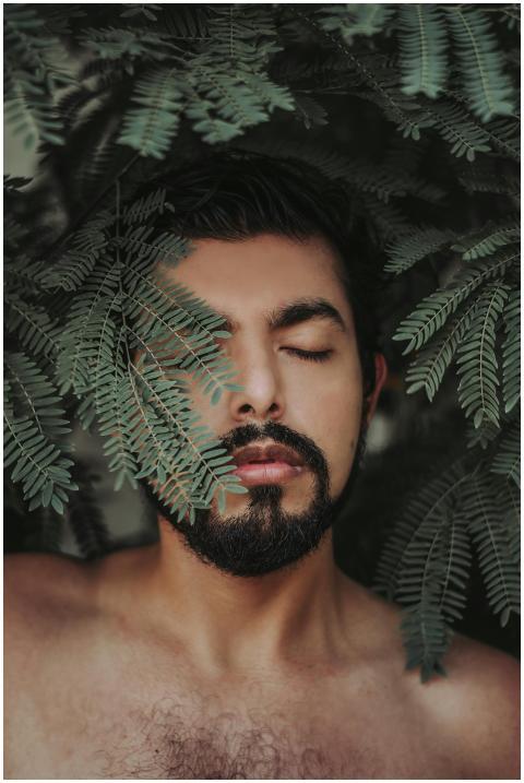 Close-up portrait of a man with closed eyes surrou