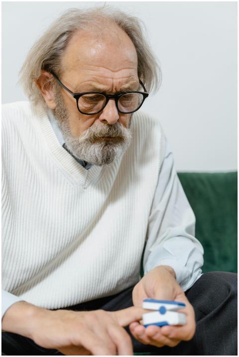 Senior man measures blood oxygen levels with a pul