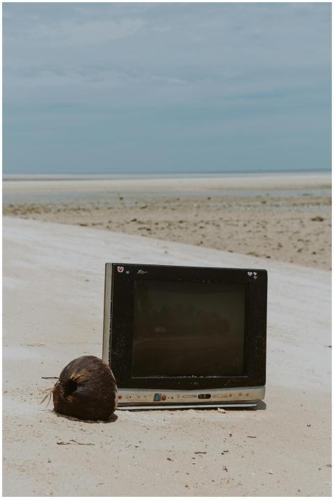 A retro television set alongside a coconut on an e