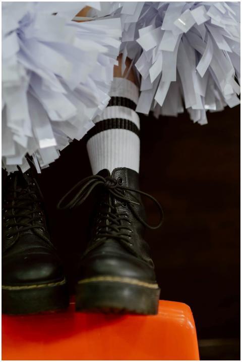 Close-up of black boots with striped socks and che