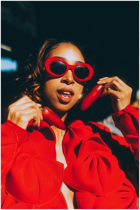 Fashionable woman in red holding chili peppers, we