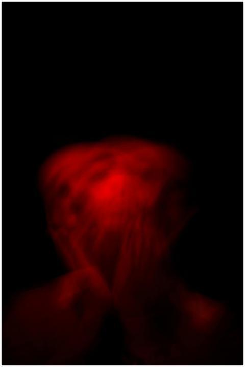 Blurred red light portrait against a black backgro