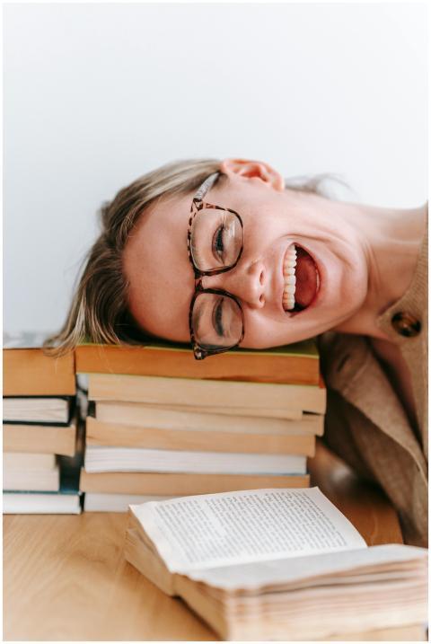 Smiling woman with glasses resting her head on a s