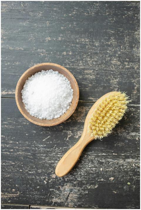 Top view of wooden brush and bowl with sea salt fo