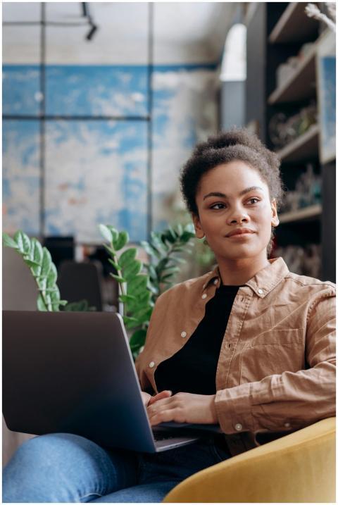 A young woman with curly hair intently works on he