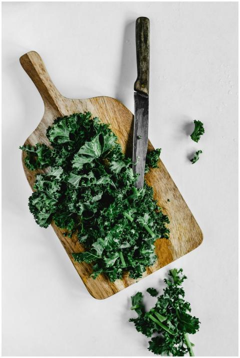 Overhead view of fresh kale on a wooden board with