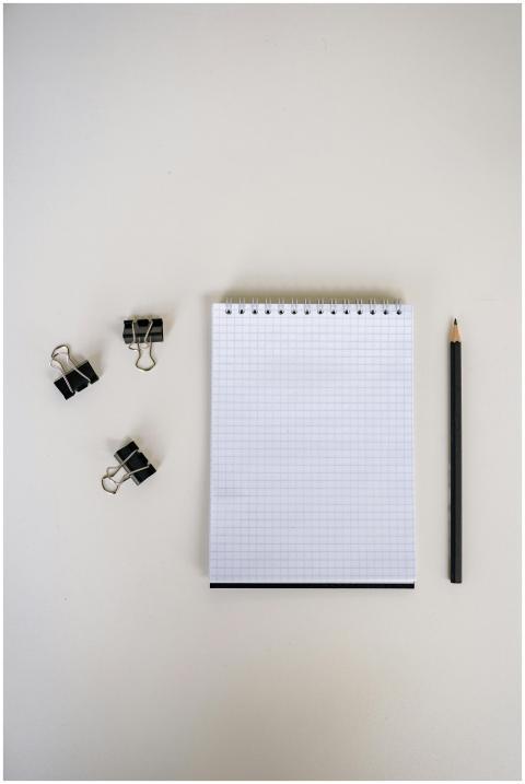 Flat lay of graph paper notebook and pencil with b