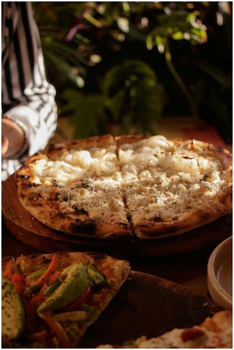 Close-up of artisan pizza with melted cheese and v