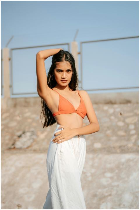 Confident woman posing outdoors in a bikini top an