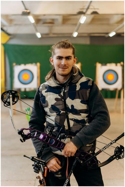 Portrait of a confident male archer holding a comp
