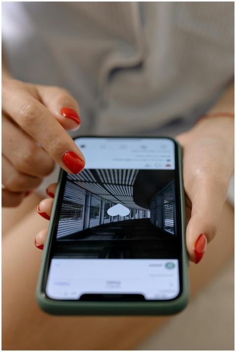 A woman with red nails uses a smartphone to browse