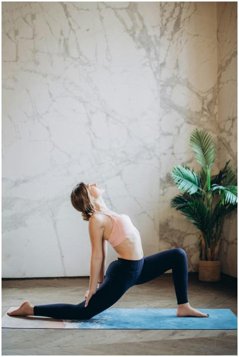 Woman practicing a deep yoga stretch indoors on a