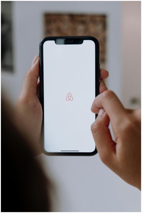 Close-up of hands holding a smartphone with Airbnb