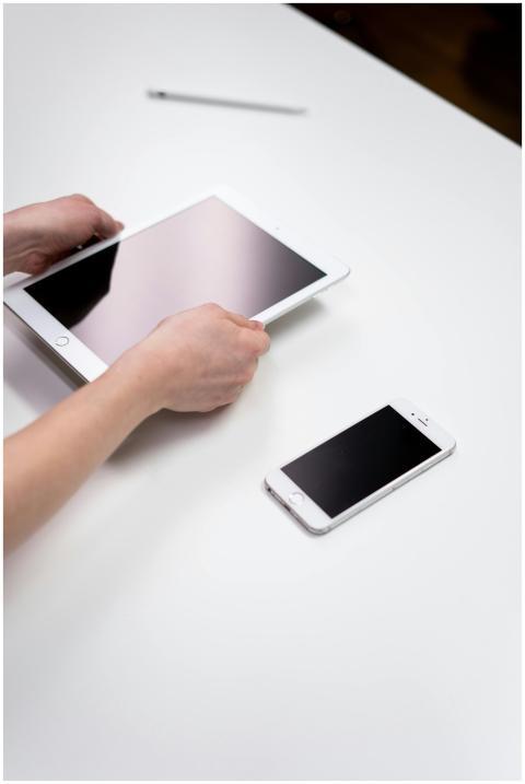 Hands interacting with a tablet and smartphone on