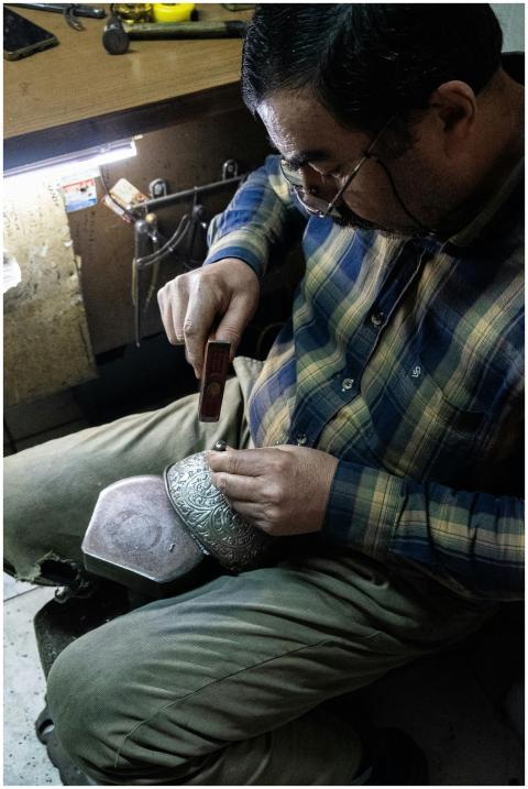 Skilled artisan meticulously engraves intricate de