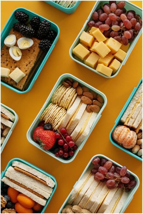 Assorted lunch boxes with snacks, fruits, and chee