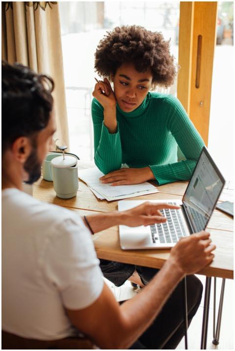 Two professionals collaborating at a desk with a l