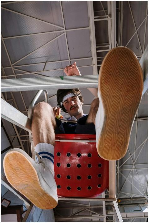 A man with a mustache in retro gym attire looks do