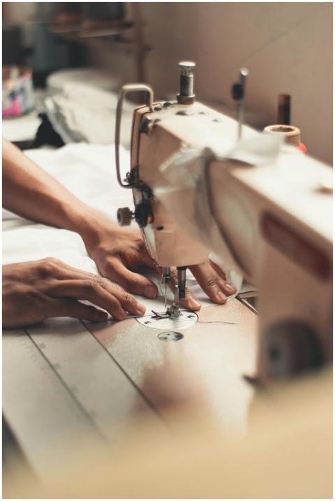 Close-up of hands using a sewing machine, depictin