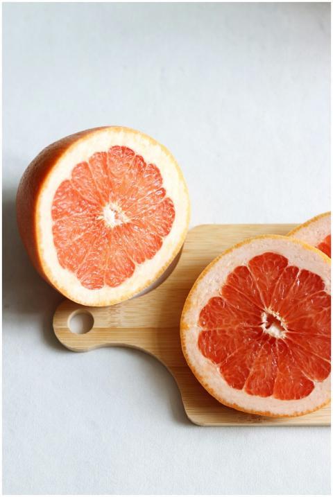 Vibrant slices of juicy grapefruit on a wooden cut