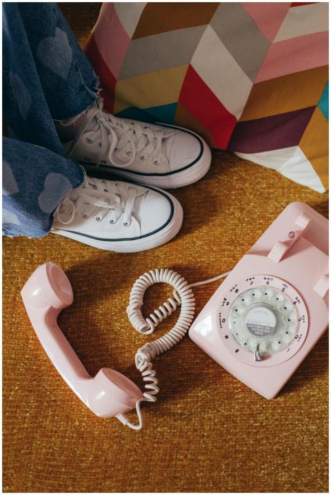 Vintage rotary phone beside stylish sneakers on co