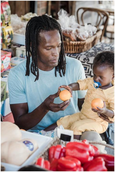 A father and his young child sharing fresh oranges