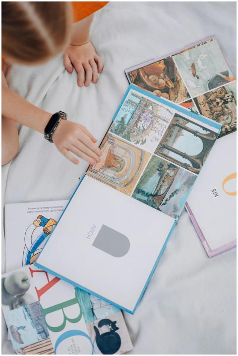 A child reading colorful books, viewed from above,